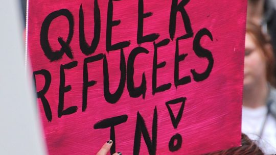 Schild mit der Aufschrift "Let queer refugees in!"
