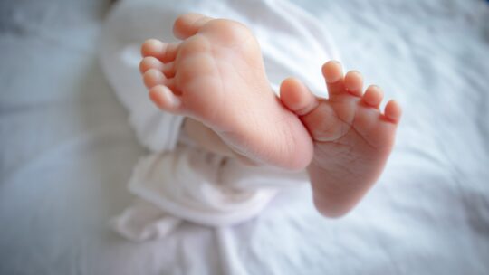 Unscharfes Bild der Füße eines Neugeborenen